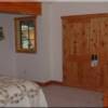 Guests and family members will rest comfortably in this bright and cheery guest bedroom with Knotty Alder closet doors